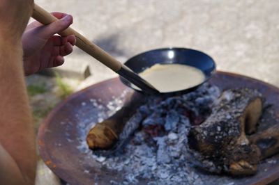 Cropped image of man cooking outdoors