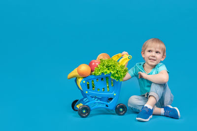 Portrait of cute boy against blue background