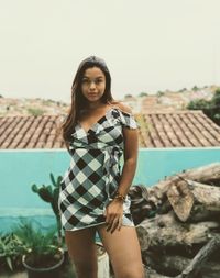 Portrait of beautiful woman standing against wall