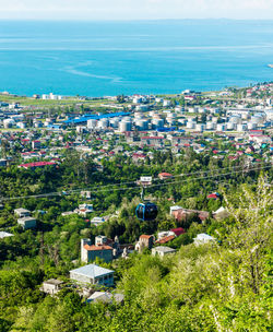 Aerial view of city by sea against sky