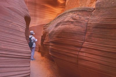 Rear view of man standing amidst rock formation