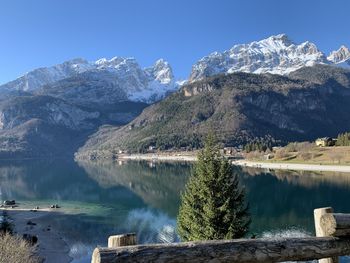 Scenic view of lake by snowcapped mountains against sky