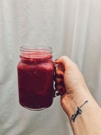 Midsection of person holding drink in jar