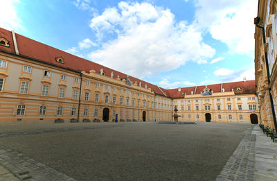 Buildings in city against cloudy sky