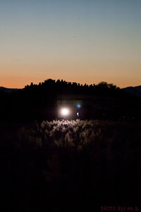 Silhouette landscape against clear sky at night