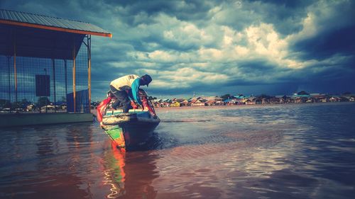 Man working in sea against sky