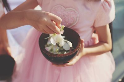 Close-up of woman holding pink flower