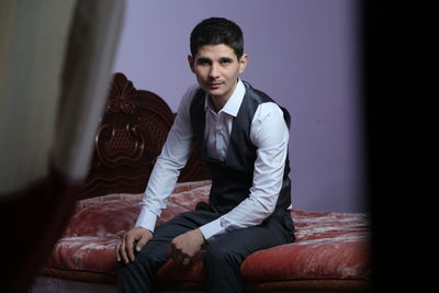 Portrait of young man sitting on sofa