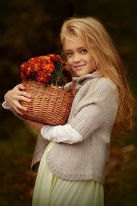 Close-up portrait of smiling girl holding basket