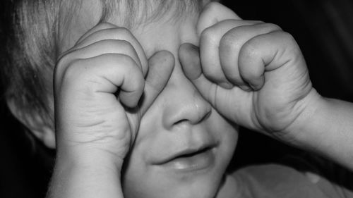 Close-up of little boy crying in room