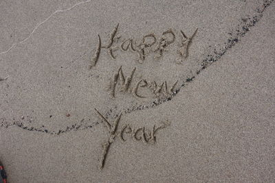 High angle view of text on sand at beach