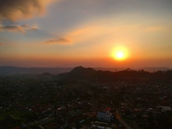 High angle shot of townscape against orange sky