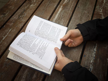 High angle view of man reading book on table