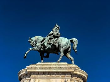 Low angle view of statue against blue sky