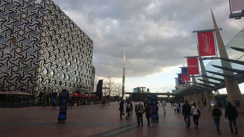 Group of people in city against sky