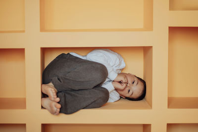 High angle view of cute baby girl sitting on table