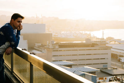 Side view of young man using mobile phone