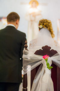 Rear view of man and woman standing against wall
