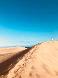 Scenic view of desert against clear blue sky