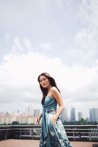 Portrait of smiling woman standing against sky