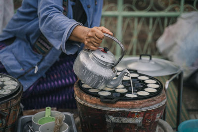 Midsection of man working with thai local dessert