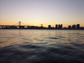 Bridge over river against sky during sunset