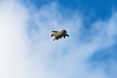 Low angle view of flag flying against sky