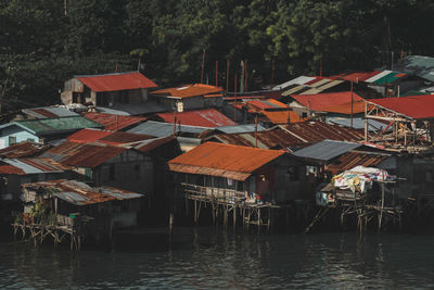 Houses by lake against buildings