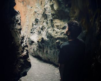 Rear view of man standing in cave