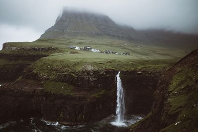 Scenic view of waterfall against sky