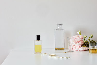 Still life with perfume, whisky, roses, necklace