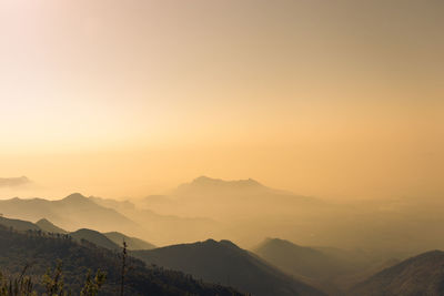 Scenic view of silhouette mountains against orange sky