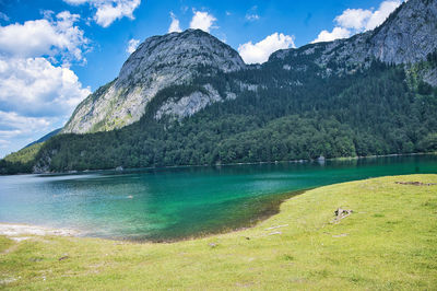 Scenic view of lake by mountain against sky