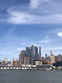 Sea by buildings against sky in city