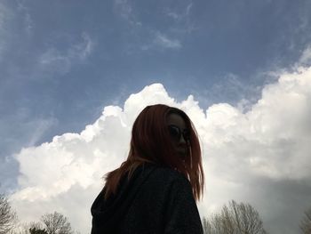 Low angle view of woman standing against sky