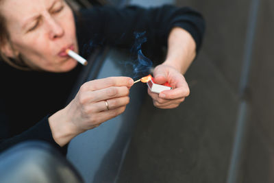 Close-up of woman lighting cigarette