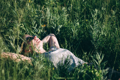 Woman lying on grassy field