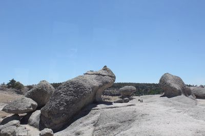 Scenic view of rocks against clear blue sky