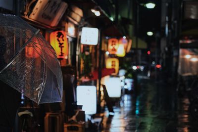 Illuminated lanterns hanging in city during rainy season