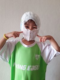 Portrait of cute boy standing against wall