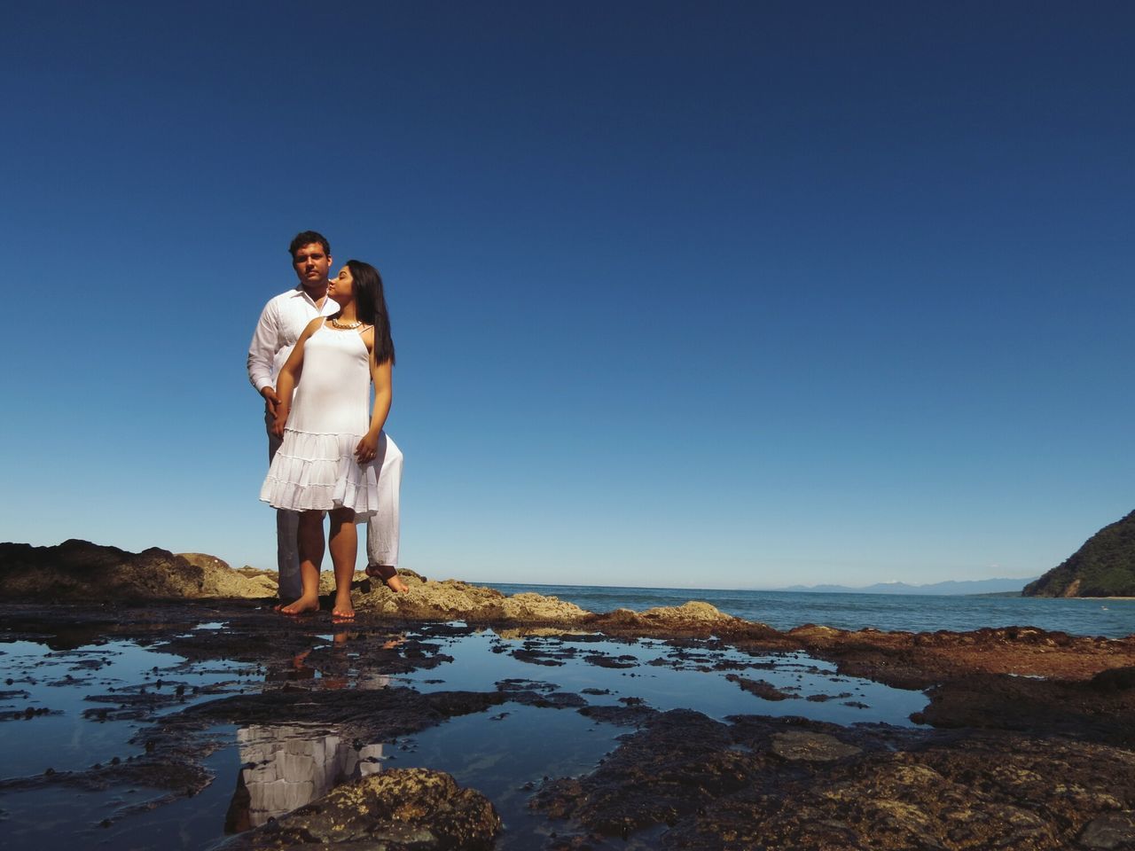 water, sea, clear sky, copy space, rock - object, blue, horizon over water, tranquility, tranquil scene, nature, beauty in nature, scenics, sculpture, full length, human representation, rock, shore, beach, statue, rock formation