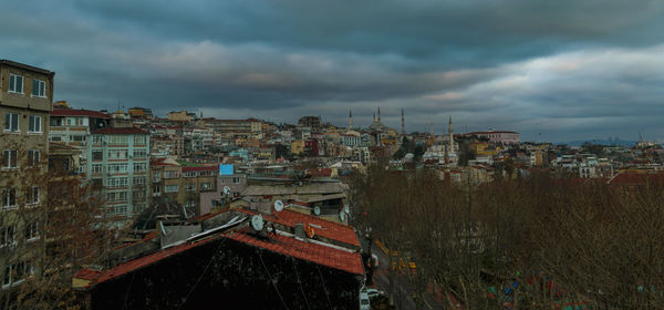 View of cityscape against cloudy sky