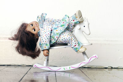 Doll on rocking horse at home