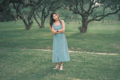 Portrait of young woman standing on field