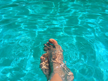 Low section of person swimming in pool