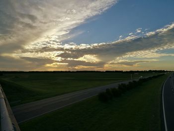 Scenic view of agricultural field against sky during sunset
