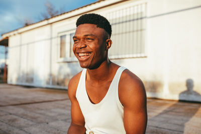 Portrait of smiling man standing against brick wall