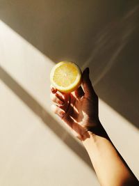 Cropped hand of woman holding lemon