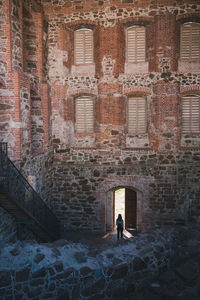 Rear view of woman walking towards door