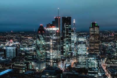 Illuminated cityscape against sky at night